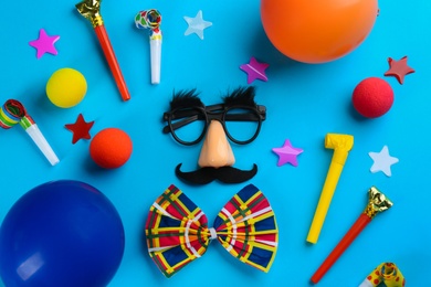 Flat lay composition with clown's accessories on light blue background