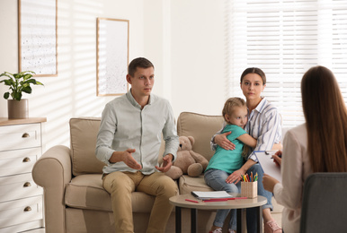 Family on appointment with child psychotherapist indoors