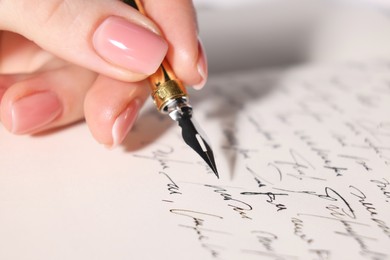 Photo of Woman writing letter with fountain pen, closeup