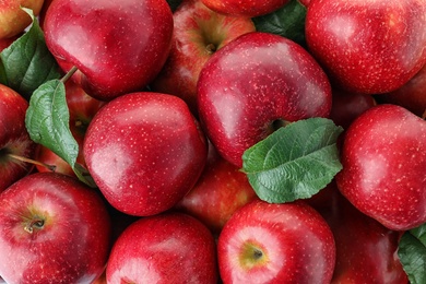 Many ripe juicy red apples as background