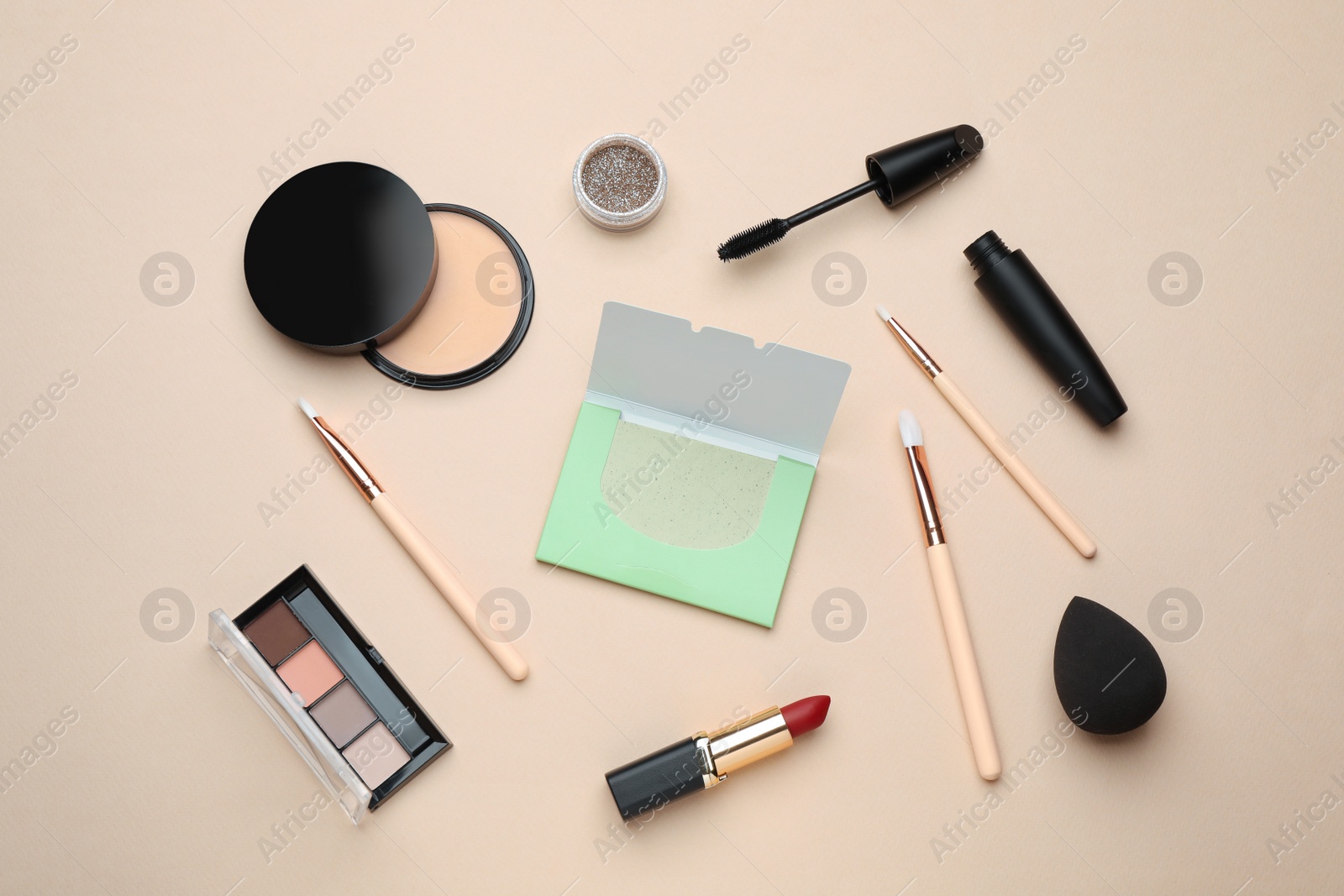 Photo of Facial oil blotting tissues and different decorative cosmetics on beige background, flat lay. Mattifying wipes