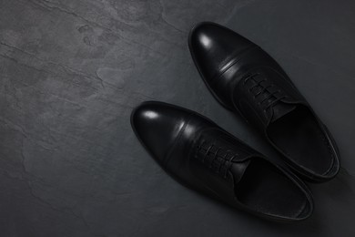 Photo of Pairleather men shoes on black surface, top view. Space for text