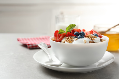 Image of Tasty granola with yogurt and berries served for breakfast on light table