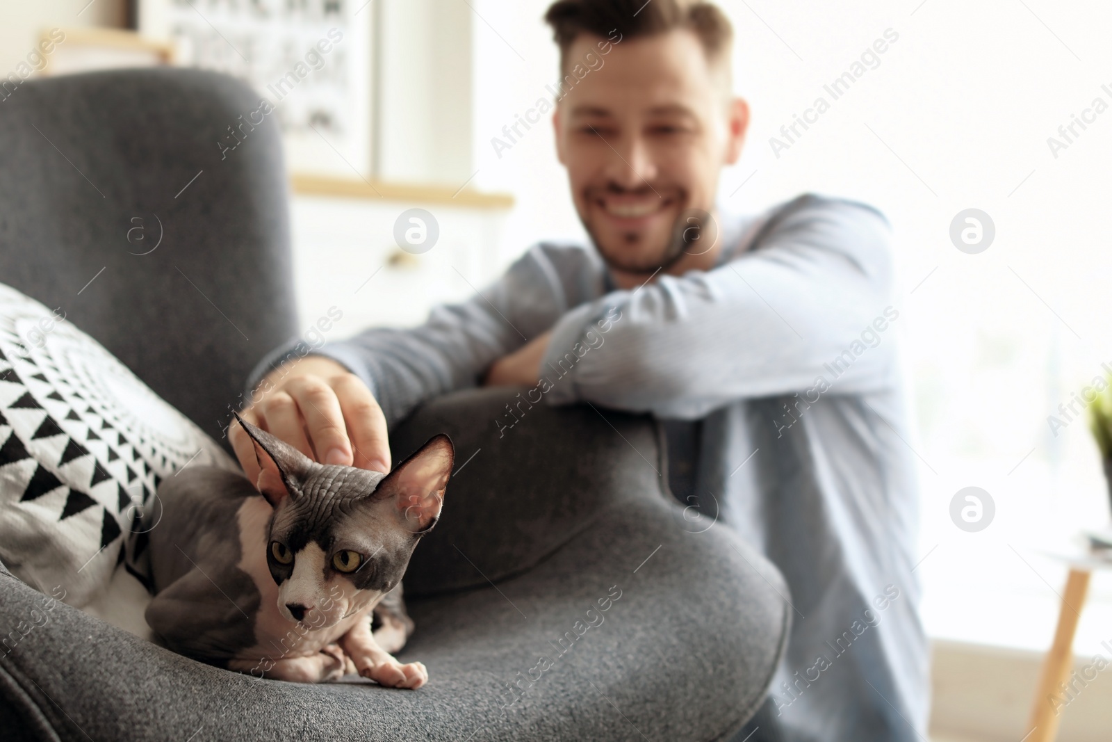 Photo of Young man with cute cat at home