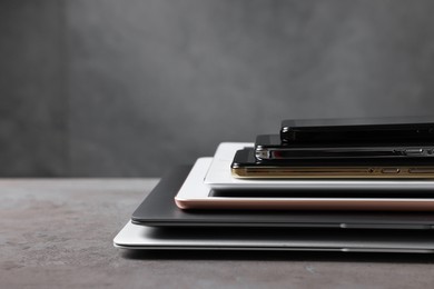 Photo of Many different modern gadgets on grey table. Space for text