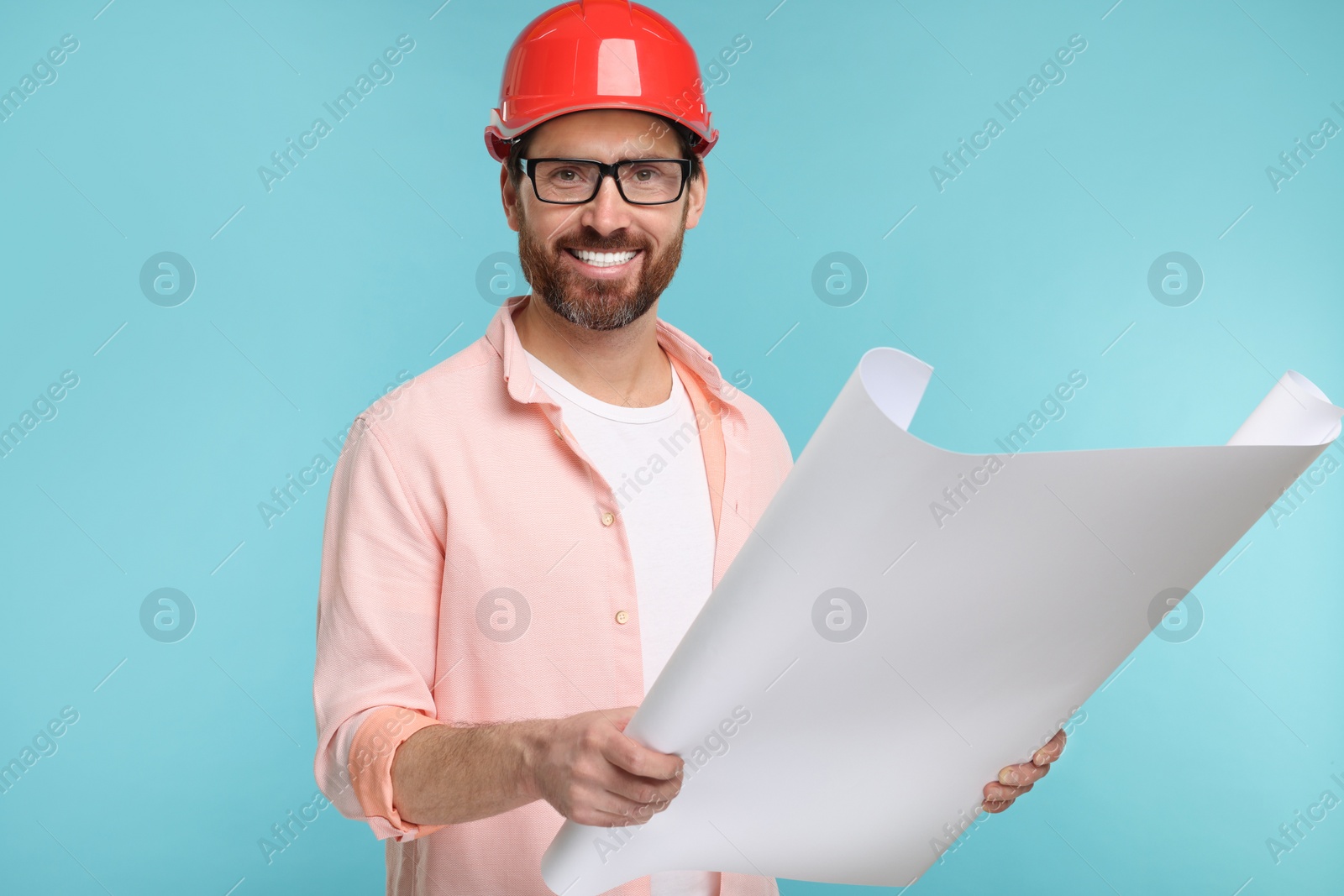 Photo of Architect in hard hat with draft on light blue background