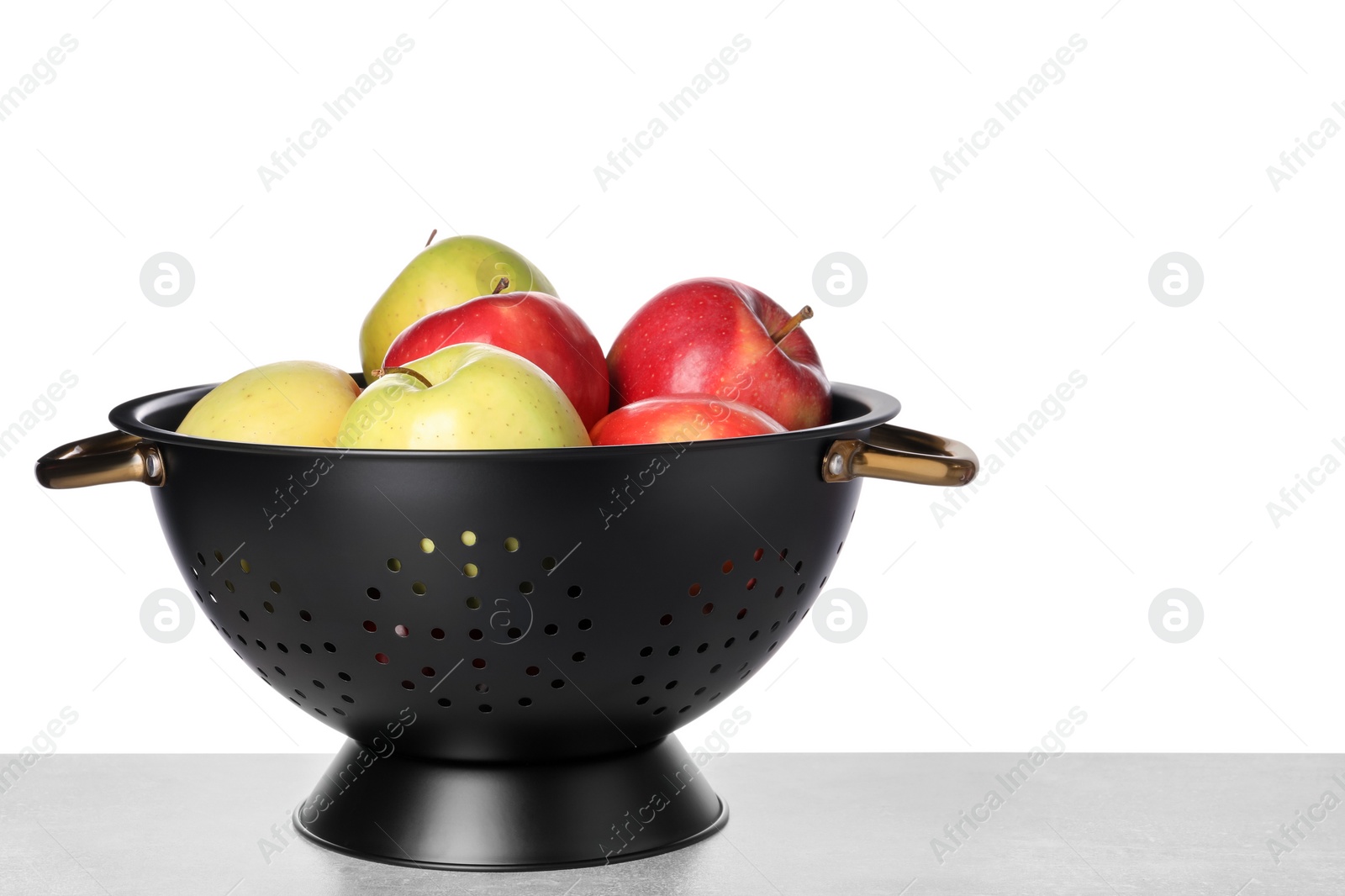 Photo of Fresh apples in colander on table against white background. Space for text