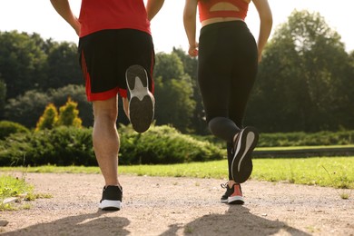 Healthy lifestyle. Couple running outdoors on sunny day, closeup