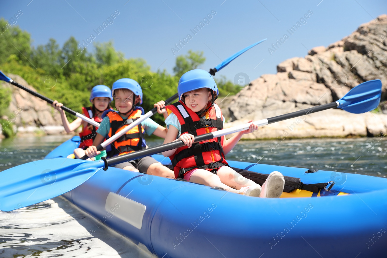 Photo of Little children kayaking on river. Summer camp