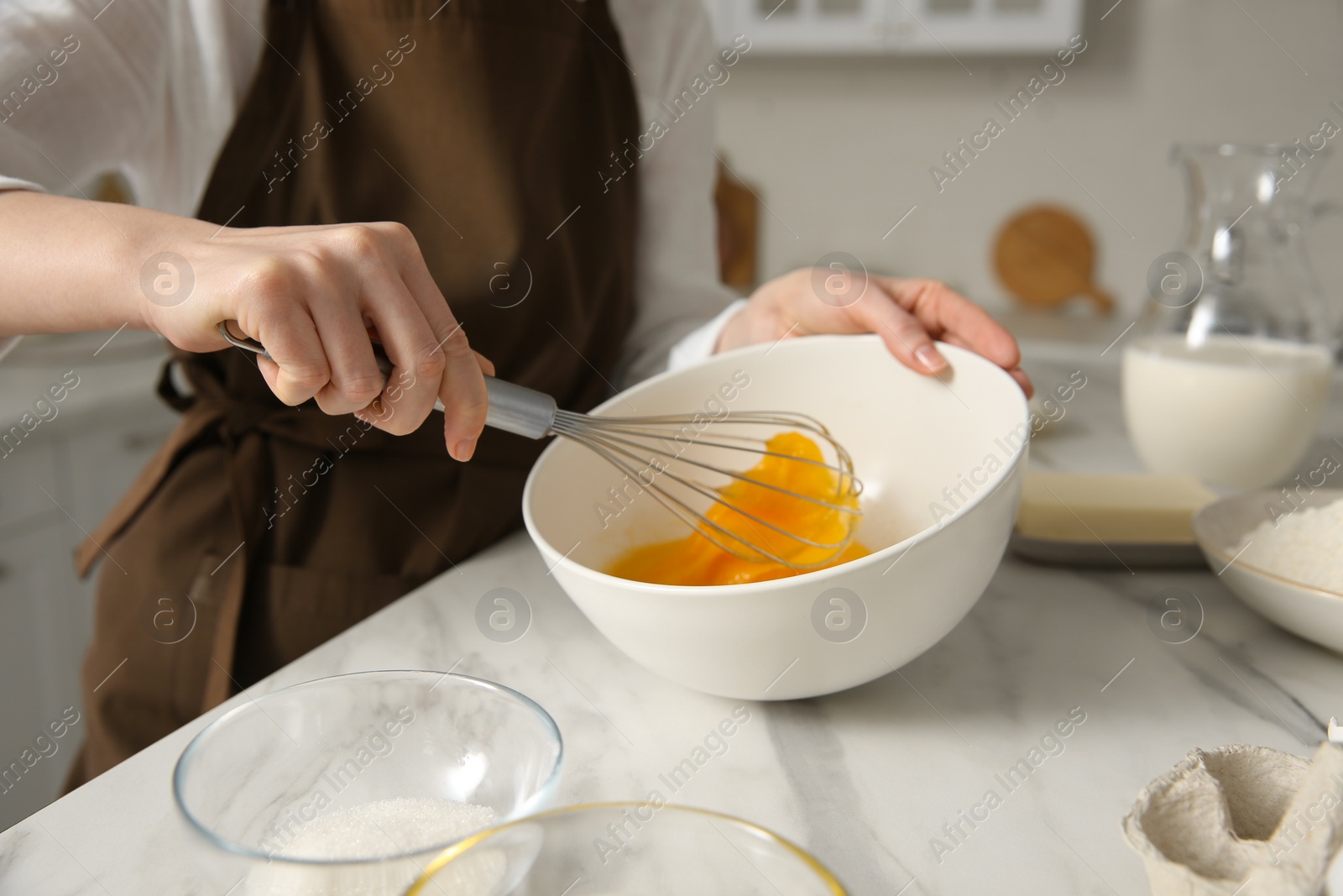 Photo of Woman making dough at table in kitchen, closeup