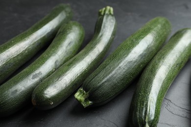 Photo of Green ripe zucchinis on black slate table, closeup