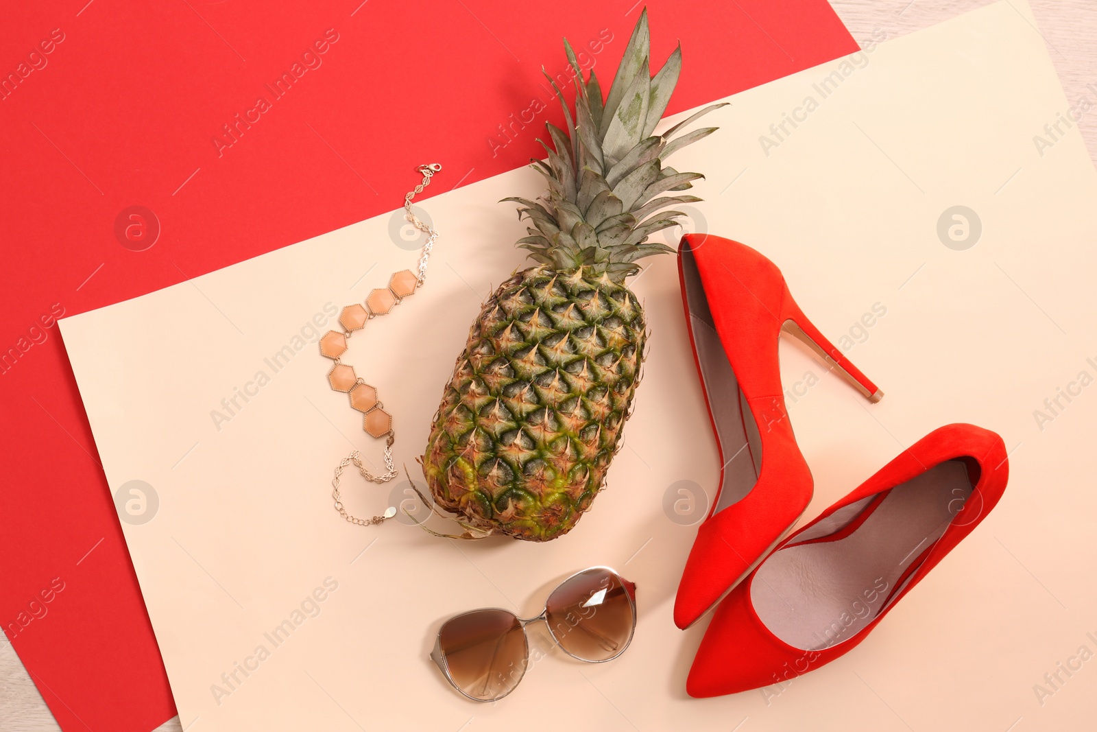 Photo of Flat lay composition with ripe pineapple, sunglasses and shoes on color background