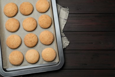 Photo of Baking sheet with delicious sugar cookies on wooden table, top view. Space for text