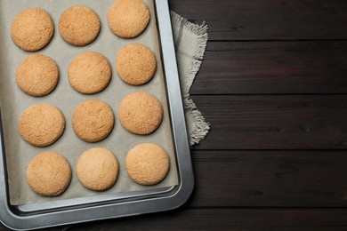 Baking sheet with delicious sugar cookies on wooden table, top view. Space for text