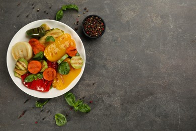 Photo of Delicious grilled vegetables served on grey table, flat lay. Space for text