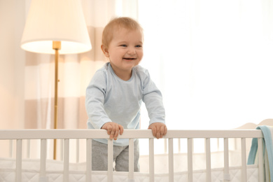 Photo of Cute little baby in crib at home