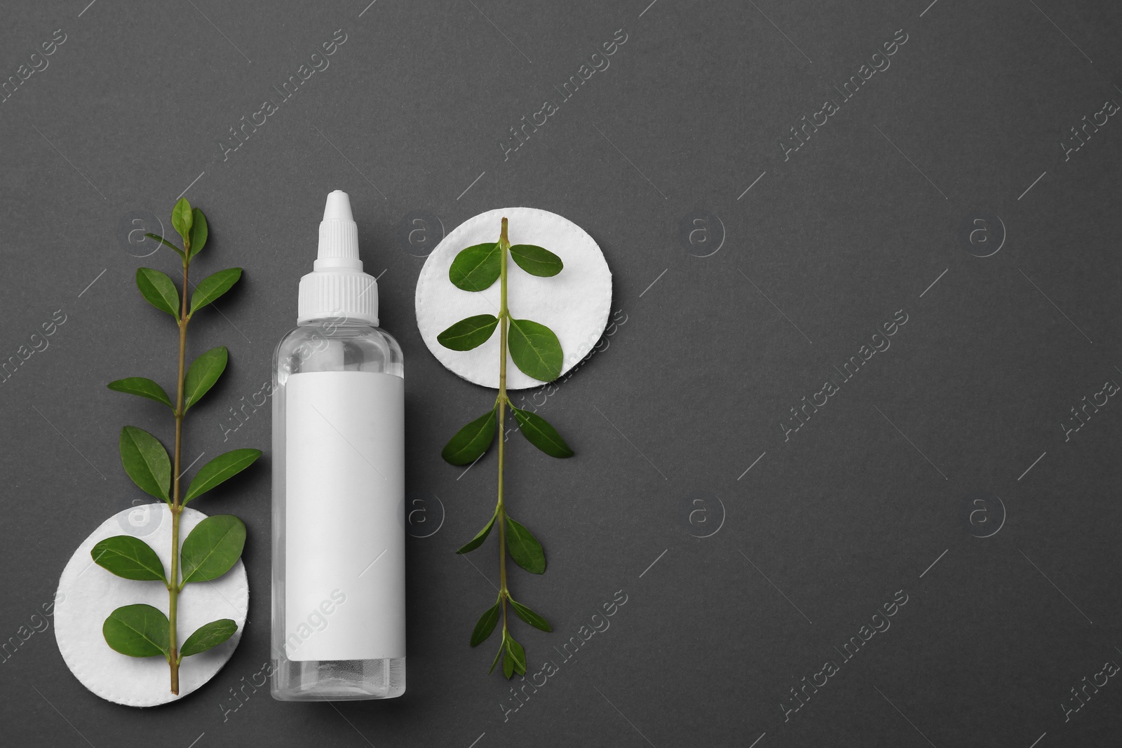 Photo of Flat lay composition with makeup remover on dark grey background. Space for text
