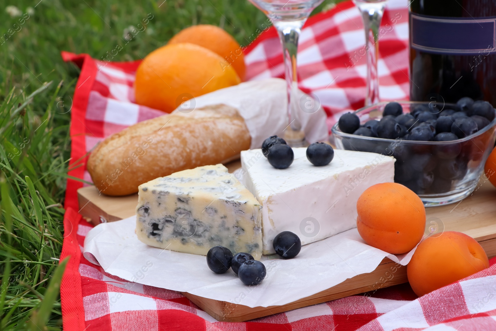 Photo of Picnic blanket with delicious food outdoors on summer day, closeup