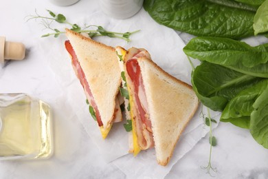 Delicious sandwiches with bacon on white marble table, flat lay
