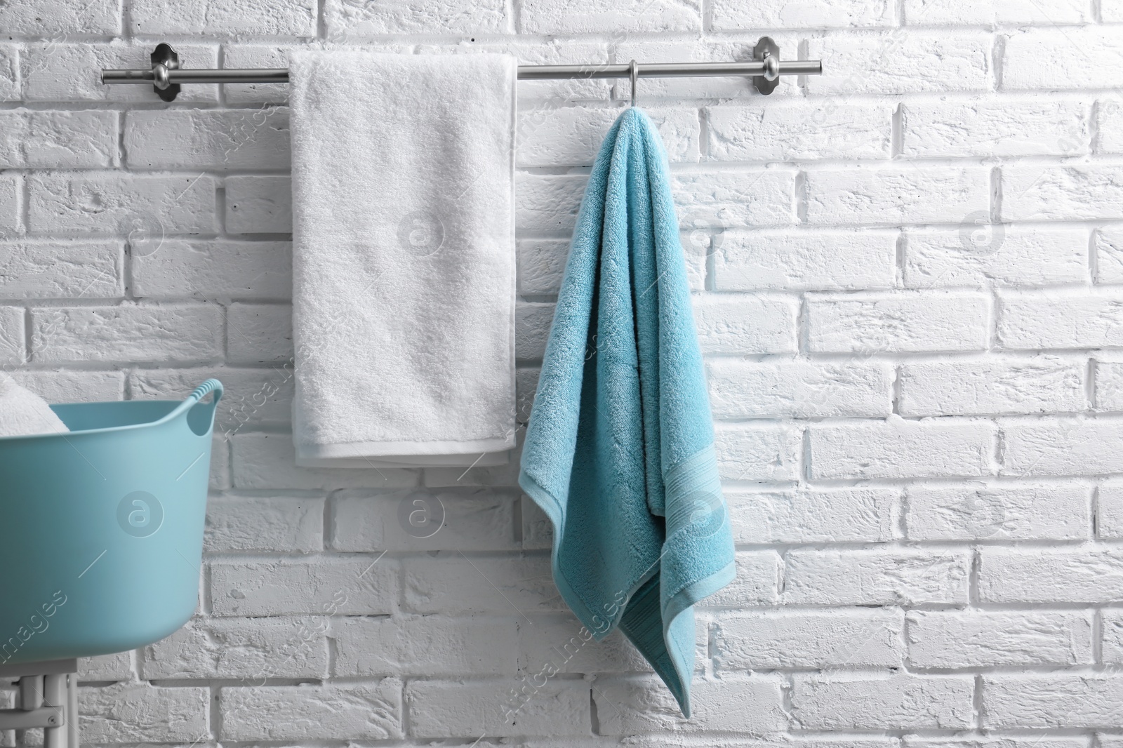 Photo of Hanger with clean towels on brick wall