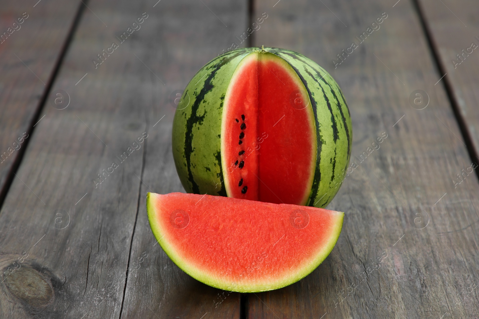 Photo of Cut delicious ripe watermelon on wooden table