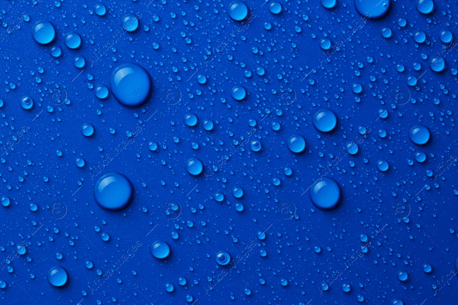 Photo of Water drops on blue background, top view