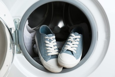 Photo of Clean sports shoes in washing machine drum