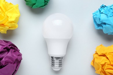 Photo of Creative flat lay composition with lightbulb and paper balls on white background. Idea concept