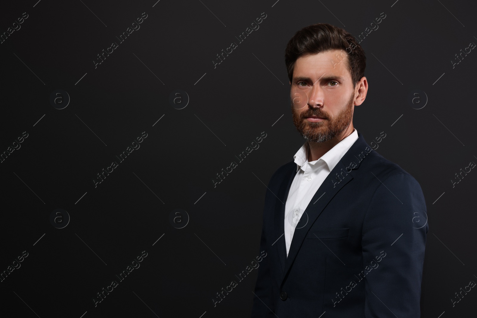 Photo of Portrait of handsome bearded man on black background. Space for text