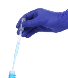 Scientist dripping liquid from pipette into bottle on white background, closeup