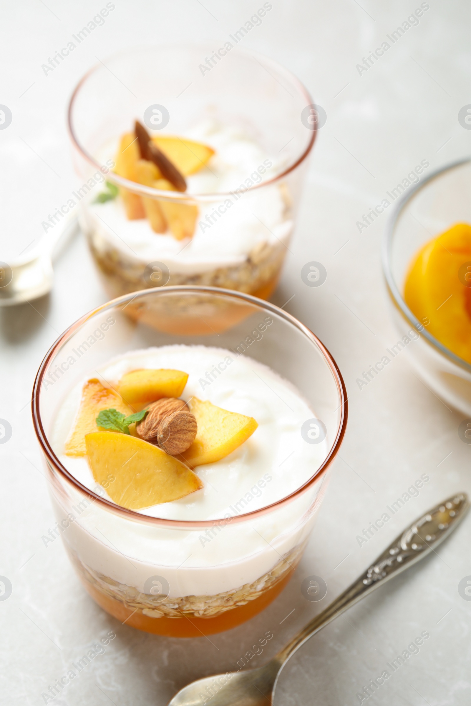 Photo of Tasty peach dessert with yogurt and granola served on light table