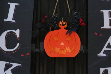 Photo of Cute Halloween decor with paper Jack O'Lantern on window, view from outside