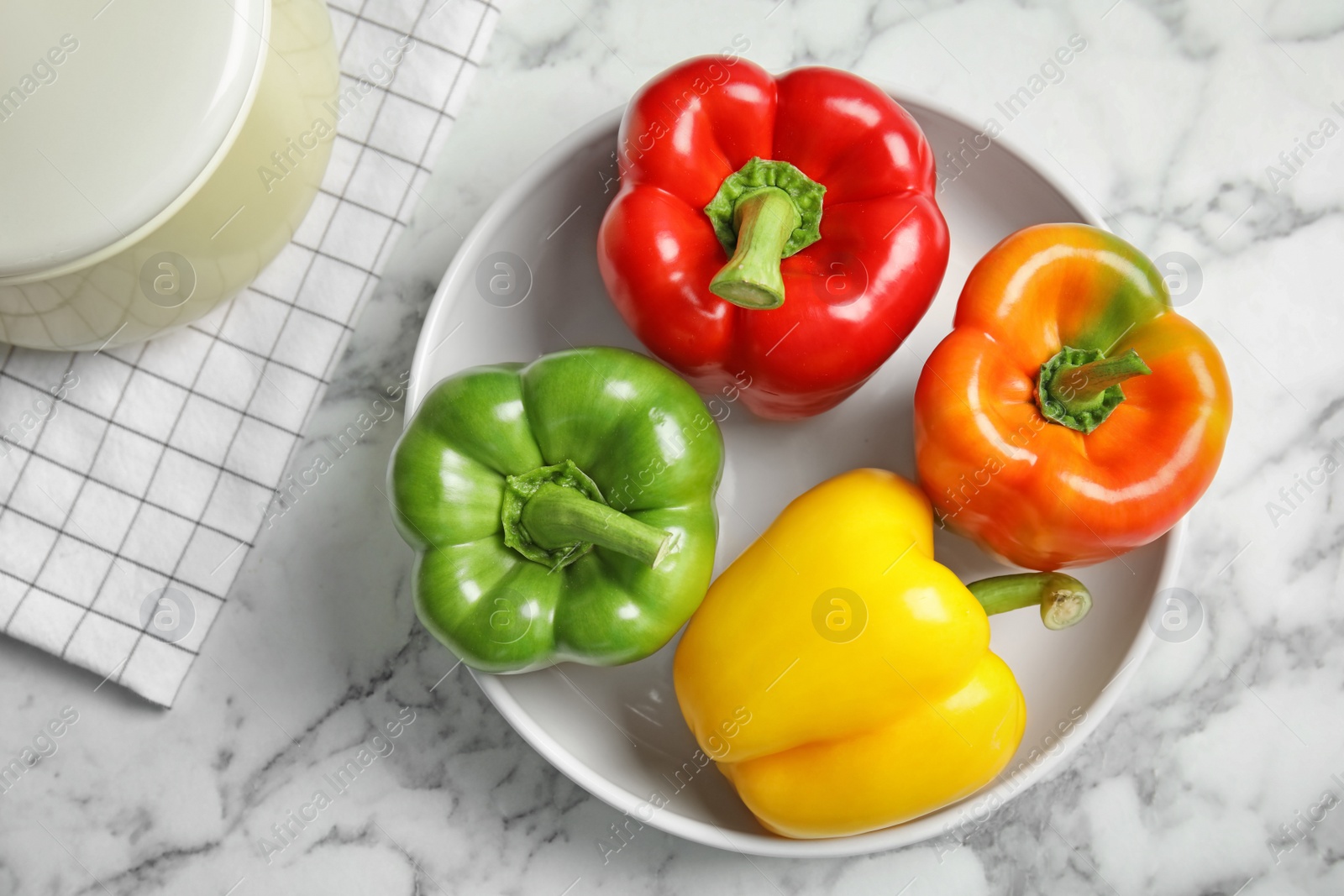 Photo of Bowl with ripe paprika peppers on table, top view