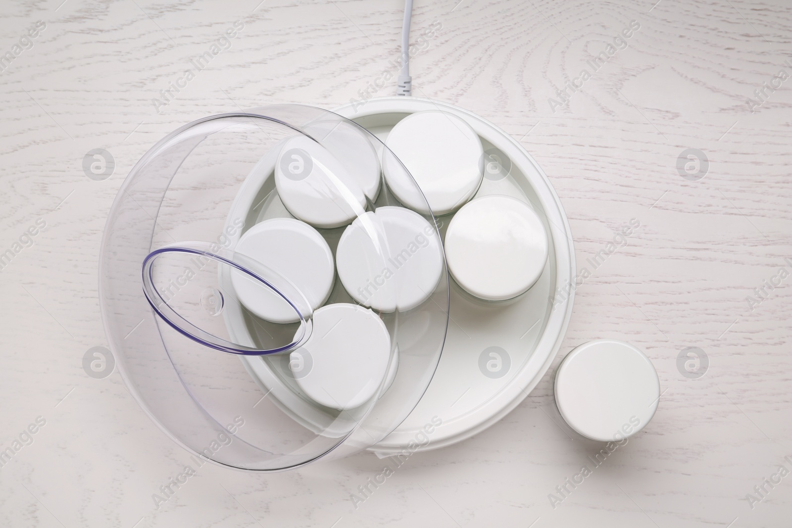 Photo of Modern yogurt maker with jars on white wooden table, flat lay