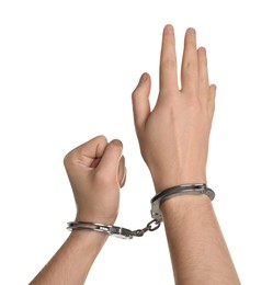 Photo of Freedom concept. Man with handcuffs on his hands against white background, closeup