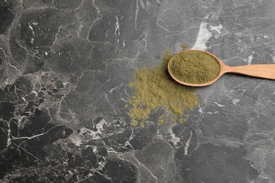 Spoon with hemp protein powder and space for text on table, top view