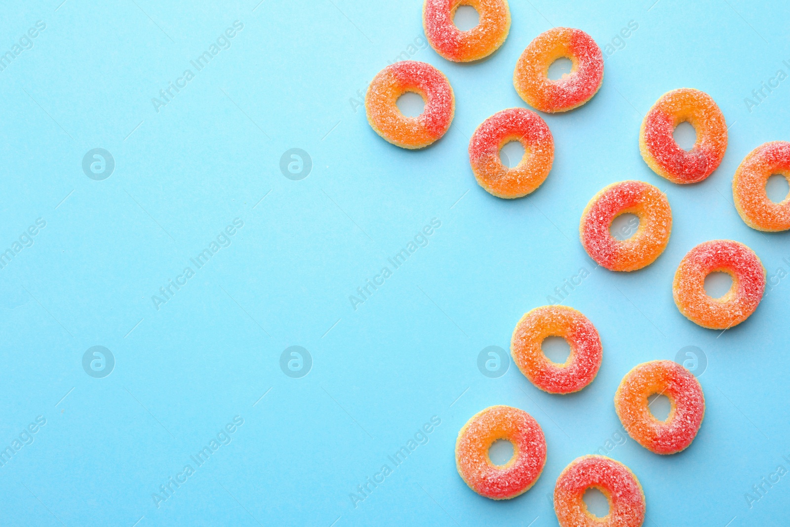 Photo of Flat lay composition with tasty jelly candies and space for text on color background