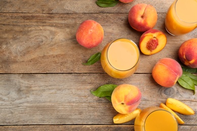 Photo of Natural peach juice and fresh fruits on wooden table, flat lay. Space for text