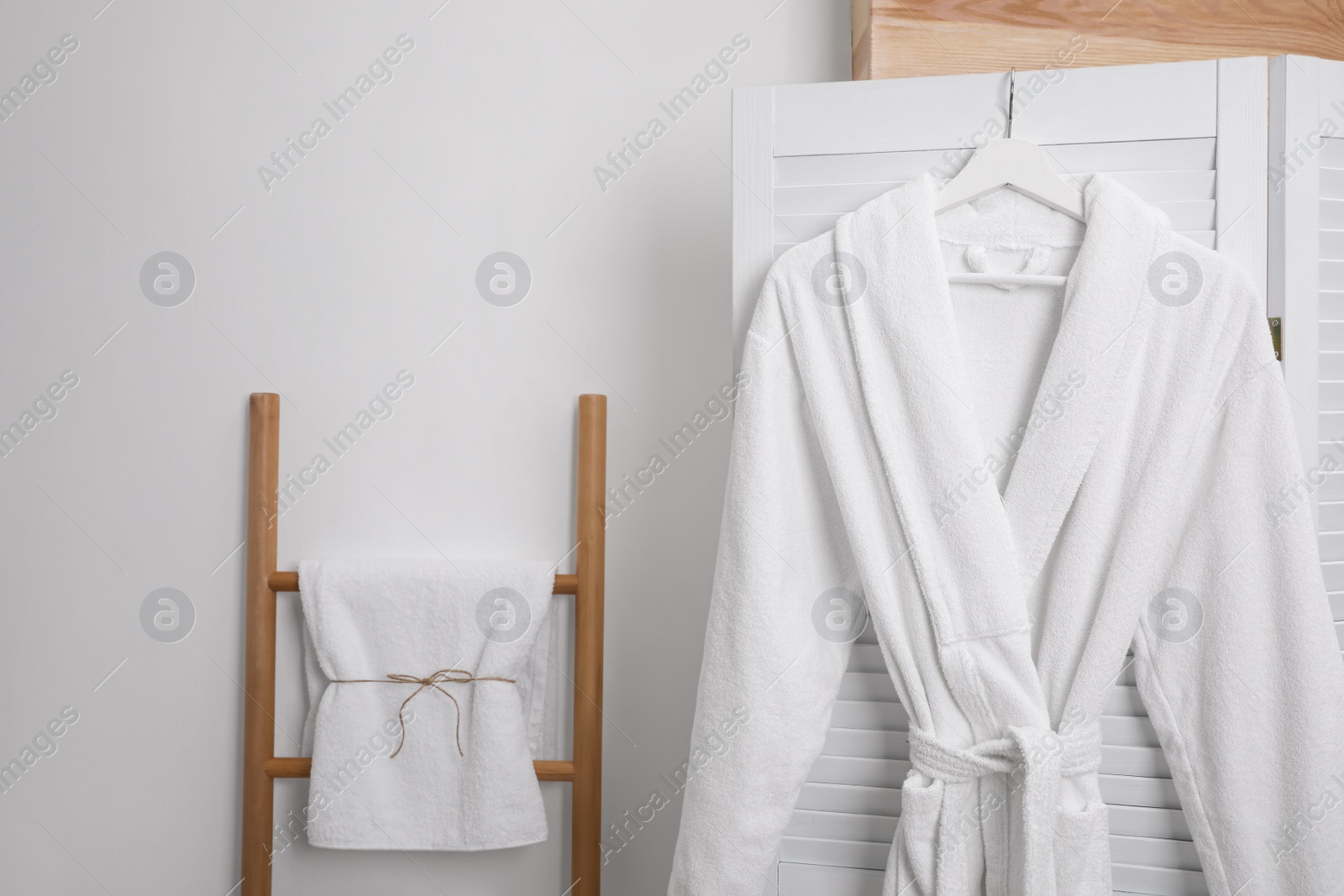 Photo of Hanger with clean soft bathrobe on screen
