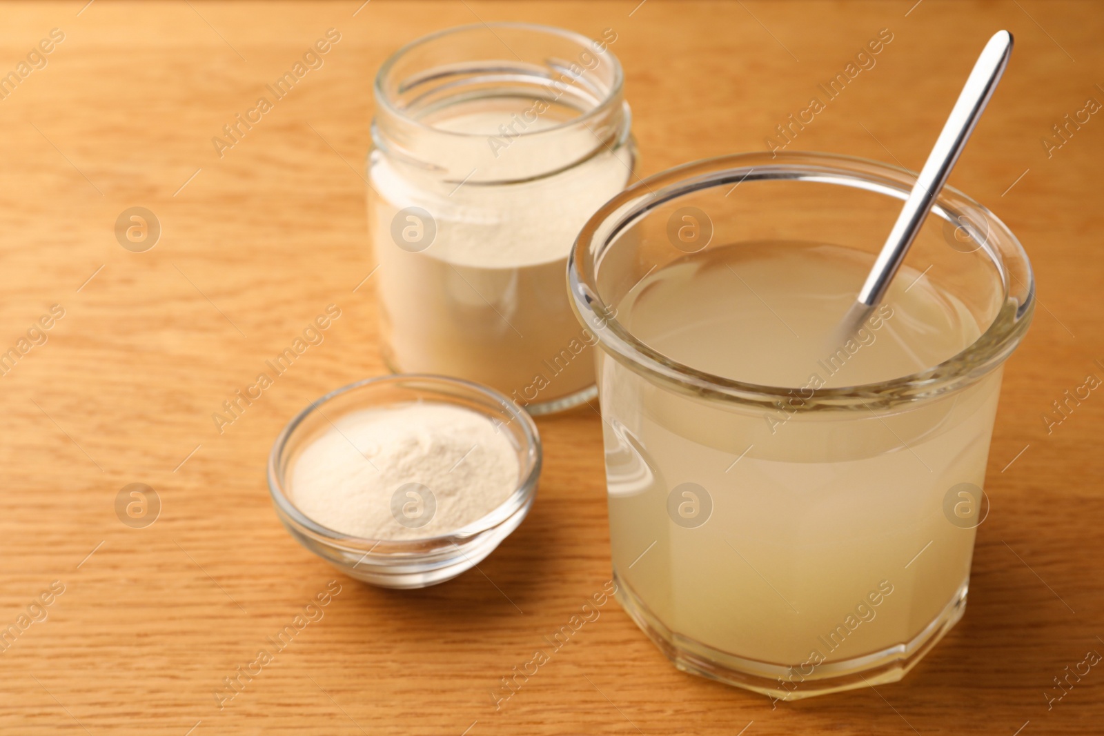 Photo of Agar-agar jelly and powder on wooden table, closeup