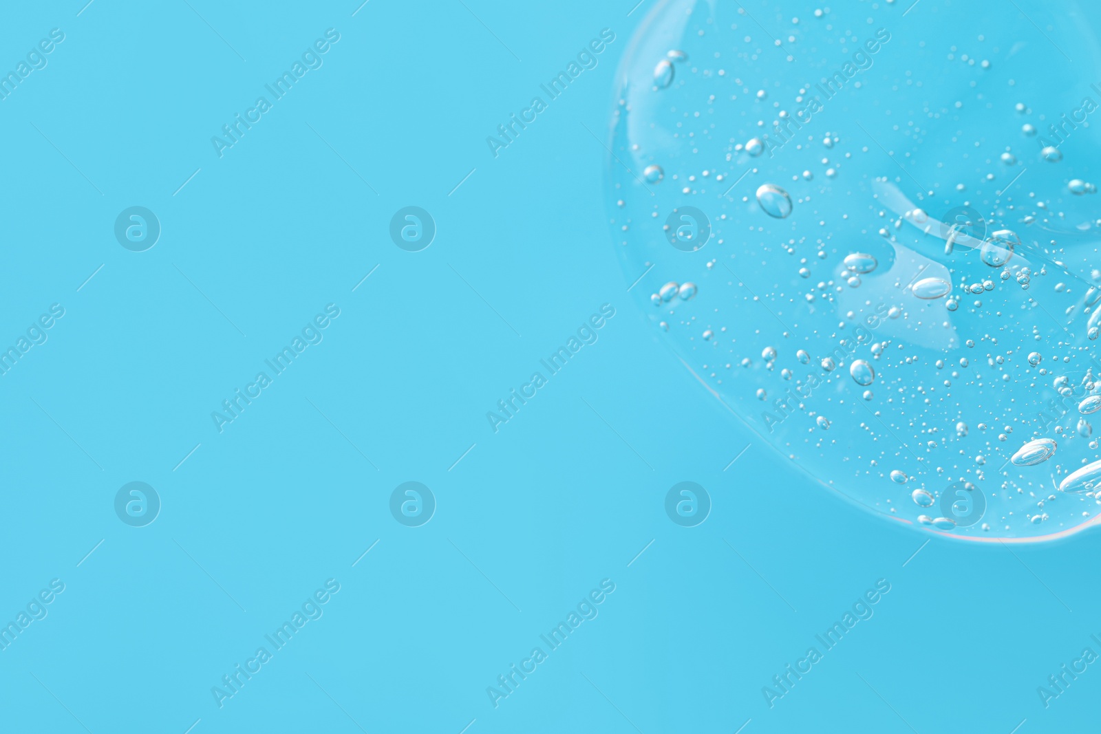 Photo of Sample of cleansing gel on light blue background, top view with space for text. Cosmetic product