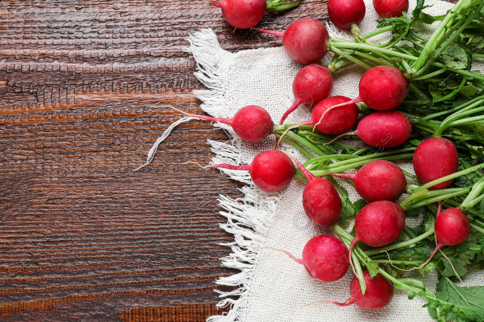 Photo of Fresh ripe radish on wooden table, flat lay. Space for text