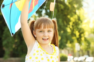 Photo of Cute little girl with kite in green park on sunny day. Happy child