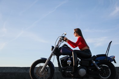 Photo of Beautiful young woman riding motorcycle on sunny day