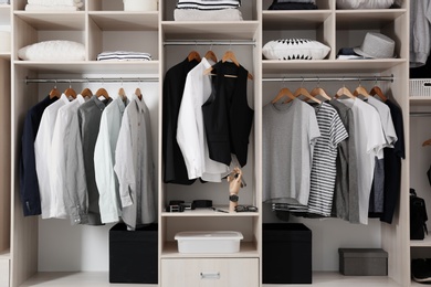 Photo of Stylish clothes and home stuff in large wardrobe closet