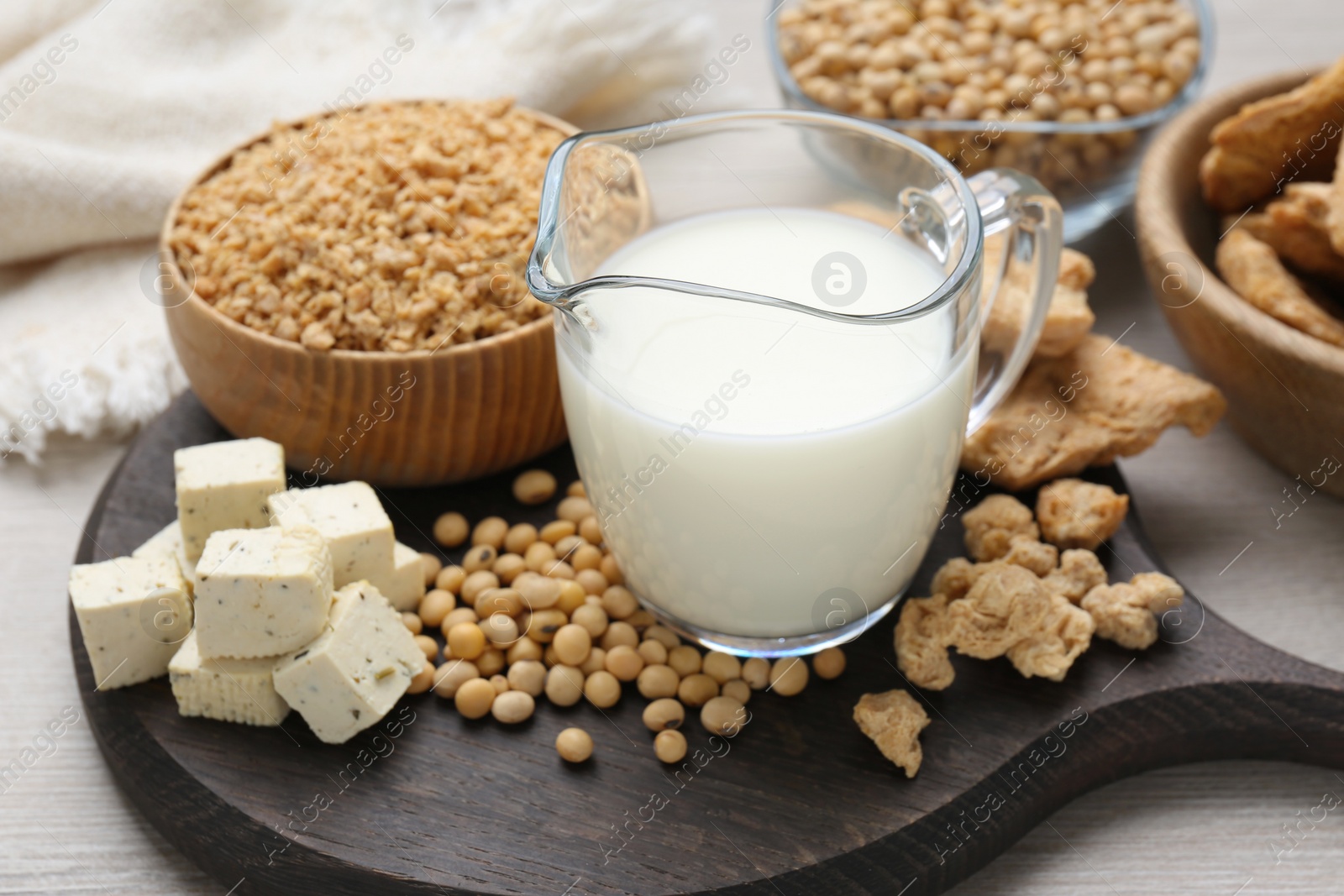 Photo of Different natural soy products on wooden board, closeup