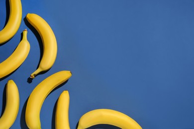 Ripe yellow bananas on blue background, flat lay. Space for text