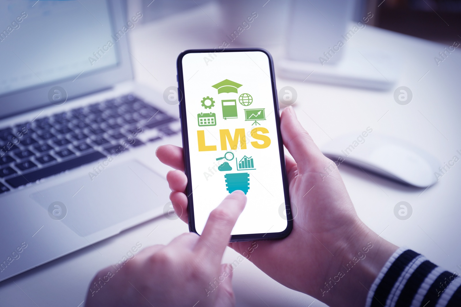 Image of Learning management system. Woman using mobile phone at table, closeup. Different icons and abbreviation LMS on screen