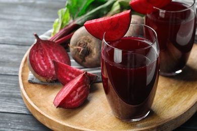 Photo of Tray with beets and glasses of juice on wooden table