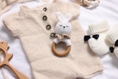 Different baby accessories on white fabric, above view